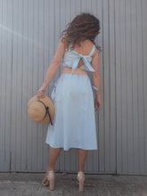 Charger l'image dans la galerie, Robe Couleurs Vintage est douce et romantique, ornée d'un élégant décolleté qui se noue au dos et laisse entrevoir quelques centimètres de peau. Ses bretelles cachent le soutien-gorge. Élaborée en coton, elle offre une bonne tenue. Sa taille élastiquée s'ajuste à la morphologie de chacune. Deux poches latérales se referment avec un nœud. Taille M, 38, 40