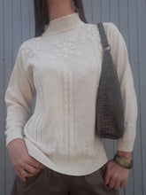 Charger l'image dans la galerie, Cynthia est un pull à l'esprit bucolique uni décoré de torsades et rehaussé de broderies florales. Il présente un col montant et des emmanchures basses. Avec un jean il formera une tenue romantique. Finitions bords-côte aux poignets, à la base est au col. Mailles fines agréables à la peau. Taille M, 36, 38, 40. Couleurs Vintage
