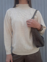 Charger l'image dans la galerie, Cynthia est un pull à l'esprit bucolique uni décoré de torsades et rehaussé de broderies florales. Il présente un col montant et des emmanchures basses. Avec un jean il formera une tenue romantique. Finitions bords-côte aux poignets, à la base est au col. Mailles fines agréables à la peau. Taille M, 36, 38, 40. Couleurs Vintage
