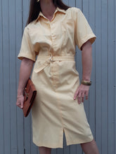 Charger l'image dans la galerie, La robe Dianne est une robe facile à vivre à l'allure décontractée et moderne dans sa jolie couleur jaune clair. Elle est agrémentée d'un col chemisier, boutonné jusqu'en dessous la taille. Et possède des manches courtes à revers et des poches plaquées sur la poitrine. Sa taille est élastiquée et s'ajuste à la morphologie de chacune grâce à une ceinture réglable cousue à la taille.